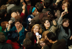 Women use compact mirrors in packed crowd to catch sight of the