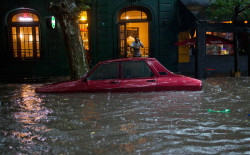 fotojournalismus:  A car is submerged in flood water in front