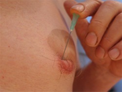 pushing needle into tit