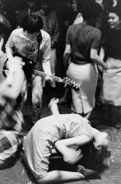 colecciones:Japan’s youth in revolt: a Tokyo Beatle plays guitar as a fan limbos on the floor. Photo by Michael Rougier.