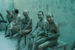 unrar:  South Korea, Boryeong. Daecheon Beach. 11th annual Mud Festival. Men cover themselves in mud and sit around chatting. 2008, Ian Berry.  