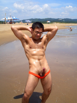 A beautiful man showing his hard cock at the beach&hellip;the people in the background, unaware of the man, make this shot very erotic.