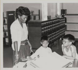 vintagelibraries:  Library staff helping two boys look up words in a dictionary, Santa Monica Public Library, year unknown.