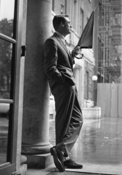 summers-in-hollywood:  Cary Grant taking shelter from the rain, April, 1957. Photo by Harry Benson