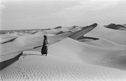 humanoidhistory:  A Bedouin stands in magnificent desert of Oman, 1949, photographed by Sir Wilfred Thesiger.(Pitt Rivers Museum)