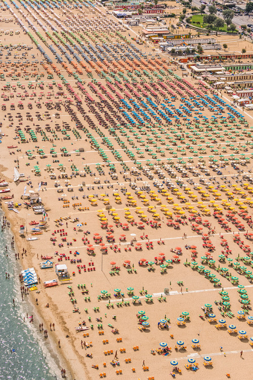 photojojo:  If you’ve been to a popular beach this summer, you know full well how incredibly crowded the seaside scene can be. Aerial photography expert Bernhard Lang captured these mesmerizing images of a packed beach along the Adriatic coast in Italy.