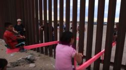 (via Művészek mérleghintákat szereltek Az amerikai-Mexikói határfalba, egy gyerekek egyből Játszani jelentése kezdtek Vele )