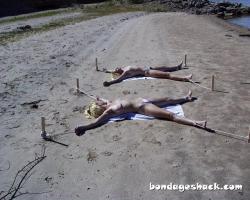 sirrendre:  two young women staked out topless on the beach   Bondage by the beach!
