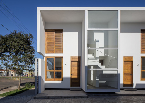 cjwho:  AV Houses, São Paulo, Brazil by Corsi Hirano Arquitetos The line of the roof extends out over the extruded glass-fronted boxes that house the staircases, creating shelters over the entrances. Half the residences have these stairs at the front