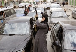 xne:  A woman rebel fighter supporter fires an AK-47 rifle as she reacts to the news of the withdrawal of Libyan leader Muammar Gaddafi’s forces from Benghazi 
