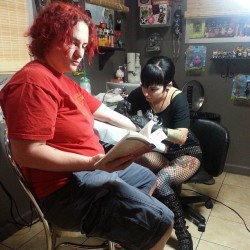 Yea she is reading while getting tatted.