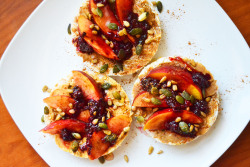 smugglinghappiness:  Rice cakes topped with peanut butter, almond butter, fresh peaches, blackberry compote, seeds, honey and cinnamon 