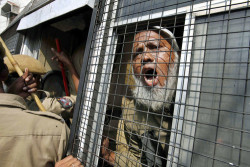 RAISING HIS VOICE: A Muslim activist shouted slogans from inside a police van during a protest Thursday in Hyderabad, India, on the 20th anniversary of the destruction of the Babri mosque in Ayodhya, India. Hindu extremists ripped apart the 16th century