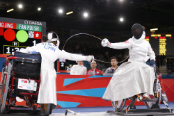 modernfencing:  [ID: two wheelchair epee fencers hitting each other.] Jing Rong (left) against Pui Shan Fan, at the 2012 Paralympics! 