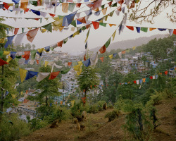 jumblepusher:Simon Norfolk. “Tibetan refugees living in the McLeod Ganj district of Dharamsala in the Dhauladhar range of the Himalayas in Northern India. Buddhist prayer flags adorn the hillsides”. 2004. Dharamsala, Himachal Pradesh, India.