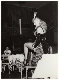 Lynne O’Neill flashes her leg to the audience, during a performance at an unidentified nightclub..