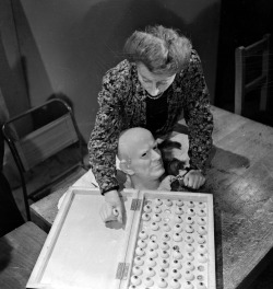 George Konig - Vera Bland chooses the right colour eyeballs for a wax head of Cardinal Bernard Griffin, Archbishop of Westminster in the workshop of Madame Tussaud&rsquo;s, London, June 1946.