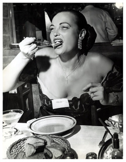STRIPPER BARES PLATE IN EATING CONTEST! Vintage press photo taken by Ingeborg Tallarek on June 3rd, 1952.. It features Burlesque dancer Lois DeFee enjoying the gastronomic competition that took place at ‘Manny Wolf’s Steak House’; located at 201