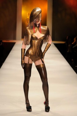 la-musemalade:  Atsuko Kudo Latex. A fully gold lace printed outfit turned heads as our 12th look on the catwalk! The look features a Tassle Cape worn with a Candy Cup Corset and High Waist Briefs, Seamed Stockings, Tassle Alejandra hat, Tassle Earrings
