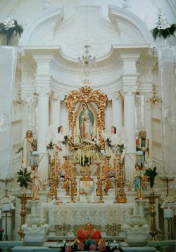 allaboutmary:  Main altar with image of Virgin of Guadalupe, plaster angels, and candlesticks, in parish church of El Pichón, near Tepic, Nayarit. From &lsquo;Mexican Churches&rsquo;