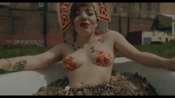 Olympia Ivleva of the fabulous Russian cultural terrorism group LITTLE BIG takes a golden bath in their video “Give me your money”.