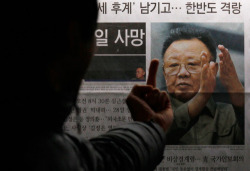  A South Korean man gestures toward a picture of the late North Korean leader Kim Jong-il as he reads the reports of his death on the newspaper company’s display board in Seoul, South Korea, on December 19, 2011.  