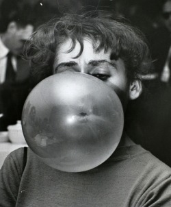 Weegee - Woman blowing a bubble, c. 1956.