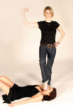 Blond in jeans posing in victory over brunette in night dress