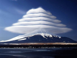 moorbay:  Lenticular clouds over Mount Fuji, Japan. These are stationary lens-shaped clouds that form at high altitudes, usually perpendicular to the direction of the wind. 