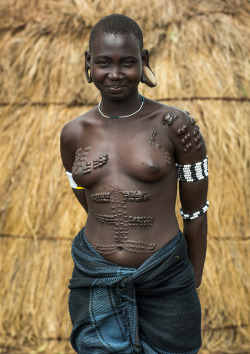 Mursi tribe woman with breast scarifications, Omo valley, Mago park, Ethiopia, by Eric Lafforgue   The skin of the tribes in Southern Ethiopia has a special reaction to cutting: the cicatrization creates raised scars. People may add ash and certain