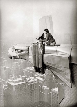 Oscar Graubner - Margaret Bourke-White perches on an eagle head gargoyle at the top of the Chrysler Building and focuses a camera, New York, 1935.