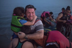 soldiers-of-war:  GREECE. Kos. August 15, 2015. Laith Majid, an Iraqi, broke out in tears of joy, holding his son and daughter, after they arrived safely in Kos on a flimsy rubber boat.Photograph: Daniel Etter for The New York Times  