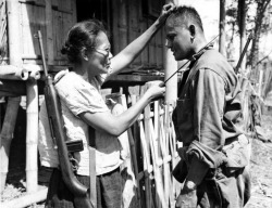 Captain Nieves Fernandez shows to an American soldier how she used her long knife to silently kill Japanese soldiers during occupation, 1944.