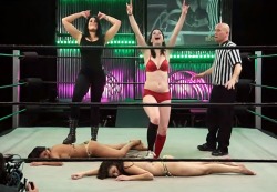 Victorious tag team, one woman Â with sneakers, the other with boots, posing over their barefoot victims