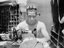 A Royal Navy Sailor On Board Hms Alcantara Uses A Portable Sewing Machine To Repair