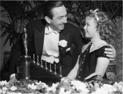 ilvillaggio:  Walt Disney receiving the Oscar from Shirley Temple for Snow White and the Seven Dwarfs, the big one and seven tiny oscars.