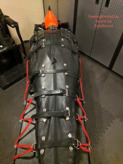 feelingknottycda:Securely attached to the bondage table by some nice tight ropes (which will be periodically tightened just that little bit more), the gimp can happily drift off in the sleepsack, isolated from the world around him by the inflated hood