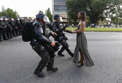 sauvamente:  sauvamente:  frontpagewoman:  This picture is breaking Twitter: Woman confronts police at BLM protest in Baton Rouge, Louisiana. Who is she?✊🏾  All that riot gear and they look shook and all she got is a sundress and her will. Black