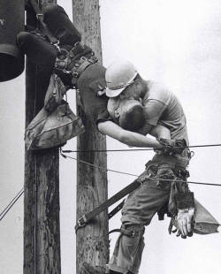 A utility worker giving mouth-to-mouth to a co-worker after he accidentally touched a high voltage wire (1967).  