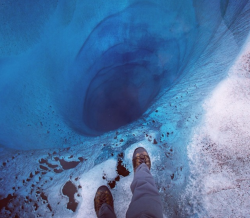 sixpenceee:  1000 ft hole found at Lower Ruth Glacier in Alaska covered only by a sheet of clear ice. This was photographed by Aaron Huey. In his words, “Staring down what could be a 1,000ft deep worm hole through the blue ice of the Lower Ruth Glacier.