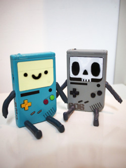 tinycartridge:  BMO Boy by Clog Two The other chap next to the adorable Adventure Time portable is MO-Death, whom Clog Two describes as “a circuit board being, that awaits BMO’s last breath.” But… I don’t want BMO to die ever. BUY Adventure