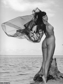 girl-o-matic: Bunny Yeager loved using sheer fabric to drape and she shot many models with the same black or red tulle Bettie uses in this photo. Shot in Key Biscayne, FL - 1954. From the book Bettie Page, Queen of Curves by Petra Mason. 