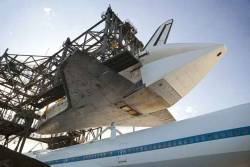 “Space shuttle Discovery is lowered onto the Shuttle Carrier Aircraft in the mate-demate device during mating operations.““Discovery begins being lowered for mating to NASA&rsquo;s 747 SCA.““Mating device (front) attaching the ships together.““Shuttle