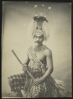 By Thomas Andrew, 1890-1894, via Auckland Museum:  Kalolo: Portrait of a man wearing regalia, a mixture of European and traditional materials, holding club.