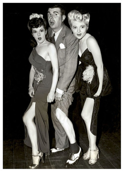 Showgirls Odessa Lauren (Left) and Doris Duane (Right) sandwich comedian: Ken Murray, in a publicity photo for his popular &ldquo;Blackouts of Ken Murray&rdquo; Burlesque show..