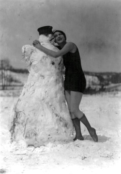 Miss Fritzi Ridgeway does her best to try and melt this happy looking snowman, April 2, 1924.