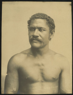 By Thomas Andrew, 1890-1920, via Auckland Museum:  Vaiala Chief: Portrait of a Samoan man with moustache, bare chest, from waist up.