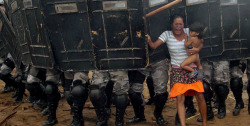 daughteroftyche:  An indigenous woman holds her child while trying to resist the advance of Amazonas state policemen in Manaus who have been sent to evict natives. [2008] 