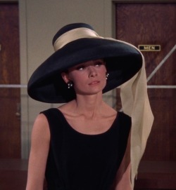 the-animation:  Audrey Hepburn in a petit noir Givenchy (cloqué silk), with a slightly flared frilly skirt, a wide-brimmed hat with an enormous cream silk bow and low-heeled alligator shoes.                                                     Breakfast