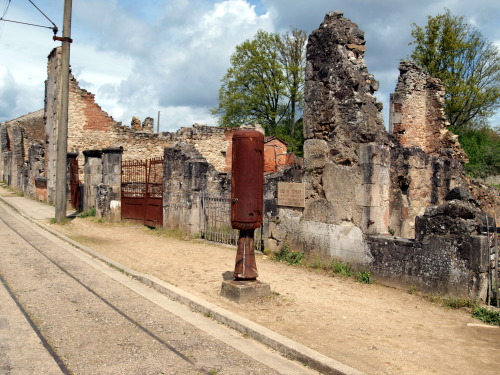 sixpenceee:  Oradour-Sur-Glane: This town was abandoned because the Nazis rounded all the citizens up and killed them. France left the entire town untouched as a memorial. The people were buried, but the items; cars, bikes, baby carriages, still remain.